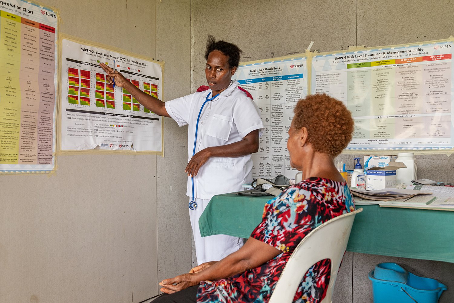 Virginia Legaile, a provincial NCD coordinator, explains a SoIPEN cardiovascular risk chart to patient Jane Teva at the Tulagi Clinic.